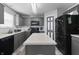 A spacious kitchen with grey cabinets, an island, and black appliances at 10312 Gladeview Dr, Indianapolis, IN 46239