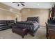 This main bedroom features a tufted leather bed frame, ceiling fan and ensuite bathroom at 10312 Gladeview Dr, Indianapolis, IN 46239