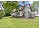 Backyard of home with mature trees and green grass; home has light siding at 10398 Ethel St, Carmel, IN 46280
