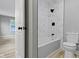 Bathroom with tub and shower combo, tile surround, and a sleek, modern toilet at 10398 Ethel St, Carmel, IN 46280