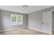 Sunny bedroom boasts a large window, gray walls, and white trim for a serene and inviting ambiance at 10398 Ethel St, Carmel, IN 46280
