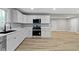 Bright kitchen features white cabinets, stainless steel appliances, marble countertops, and wood floors at 10398 Ethel St, Carmel, IN 46280
