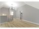A bright loft area featuring an elegant chandelier, a vaulted ceiling, and wood-look flooring at 10398 Ethel St, Carmel, IN 46280