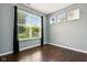 Bedroom with a large window and dark wood floors. Black curtains frame the window at 10606 Glenwyck Pl, Noblesville, IN 46060