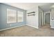 Comfortable bedroom features neutral walls, two windows for natural light, and wall shelving for storage at 10606 Glenwyck Pl, Noblesville, IN 46060