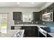 Modern kitchen features stainless steel appliances, granite countertops, dark cabinets, and tile backsplash at 10606 Glenwyck Pl, Noblesville, IN 46060