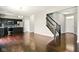 Open concept living space with dark wood floors, a kitchen, and a staircase at 10606 Glenwyck Pl, Noblesville, IN 46060