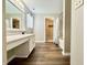 The bathroom offers a vanity and sink combo, framed mirror, and modern wood-look flooring at 10900 Clear Spring Dr, Camby, IN 46113