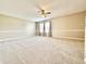 A spacious bedroom featuring plush carpet, a ceiling fan, and abundant natural light filtering through the window at 10900 Clear Spring Dr, Camby, IN 46113
