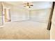 A serene bedroom with neutral decor, plush carpeting, a ceiling fan, and a hallway view at 10900 Clear Spring Dr, Camby, IN 46113