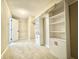 Large walk-in closet with plush carpeting, built-in shelving and storage, with a door that leads to another room at 10900 Clear Spring Dr, Camby, IN 46113