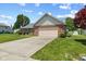 A beautiful brick home features a two-car garage, mature trees, and a well-maintained lawn at 11026 Clearspring Way, Indianapolis, IN 46239