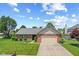 Well-manicured lawn complements this inviting brick home with an attached garage and vibrant green accents at 11026 Clearspring Way, Indianapolis, IN 46239