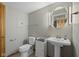 Neutral bathroom with a pedestal sink, a matching toilet and updated fixtures at 11603 Maze Rd, Indianapolis, IN 46259