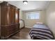 Cozy bedroom with wood floors, classic armoire, and natural light from the window at 11603 Maze Rd, Indianapolis, IN 46259