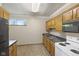 Galley kitchen featuring oak cabinets, black appliances, and a window at 11603 Maze Rd, Indianapolis, IN 46259