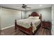 Well-lit bedroom featuring wood floors, a ceiling fan, and a decorative quilt at 11603 Maze Rd, Indianapolis, IN 46259