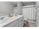 Bathroom featuring a double sink vanity, a large mirror, and a bathtub with a shower curtain at 11809 Redpoll Trl, Noblesville, IN 46060