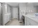 Bright bathroom featuring double sinks, white cabinets, and neutral tile flooring at 11809 Redpoll Trl, Noblesville, IN 46060