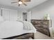 Bright bedroom featuring a ceiling fan, double closets, an open doorway and a wooden dresser at 11809 Redpoll Trl, Noblesville, IN 46060