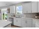Charming kitchen boasts white cabinetry, stainless steel appliances, and a view to the backyard at 11809 Redpoll Trl, Noblesville, IN 46060