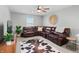 Spacious living room featuring a leather sectional, area rug, and ceiling fan at 11809 Redpoll Trl, Noblesville, IN 46060