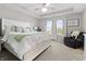 Tranquil main bedroom featuring a tray ceiling, a ceiling fan, two windows, and a sitting chair at 11809 Redpoll Trl, Noblesville, IN 46060