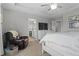 Spacious main bedroom featuring neutral walls, plush carpet, a ceiling fan, a sitting chair, and an ensuite bathroom at 11809 Redpoll Trl, Noblesville, IN 46060