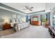 Light-filled main bedroom with tray ceilings, a ceiling fan, and cozy decor with a rocking chair at 123 Bentree Blvd, Danville, IN 46122