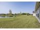 Green backyard with a pond view, minimal trees, and house on the left at 1283 Clairet, Westfield, IN 46074