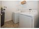 Functional laundry room featuring modern washer and dryer units with tiled flooring and overhead shelving at 1283 Clairet, Westfield, IN 46074