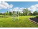 Well-manicured backyard showcasing a lush lawn, mature trees, a soccer net and landscape beds at 1345 Lewiston Dr, Westfield, IN 46074