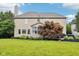 View of the house from the backyard with a large green lawn and lush landscaping around the home at 1345 Lewiston Dr, Westfield, IN 46074
