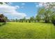 Open backyard featuring a sprawling lawn, mature trees, and a serene view of a pond at 1345 Lewiston Dr, Westfield, IN 46074