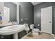 Elegant half bathroom with a pedestal sink, stylish mirror, and neutral wall paint at 1345 Lewiston Dr, Westfield, IN 46074