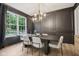 Elegant dining room with dark walls, modern light fixture, hardwood floors, and large window at 1345 Lewiston Dr, Westfield, IN 46074