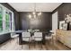 Elegant dining room with dark walls, modern light fixture, hardwood floors, and large window at 1345 Lewiston Dr, Westfield, IN 46074