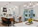 Open kitchen boasts white cabinets, hardwood floors, modern lighting, and a view of the patio at 1345 Lewiston Dr, Westfield, IN 46074