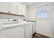 Modern laundry room with white washer and dryer, cabinets, countertop and window at 1345 Lewiston Dr, Westfield, IN 46074