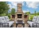 Brick outdoor fireplace on a brick patio with outdoor seating at 1345 Lewiston Dr, Westfield, IN 46074