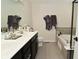 A tiled bathroom with a dual vanity, toilet, and large bathtub with a tiled surround at 13616 Whitten N Dr, Fishers, IN 46037