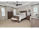 A relaxing main bedroom features a tray ceiling, neutral color palette, and wood furnishings at 13616 Whitten N Dr, Fishers, IN 46037