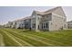 Back view of the townhomes with green grass at 14110 Bay Willow Dr, Fishers, IN 46037
