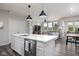 Open kitchen with stainless steel appliances, modern island and connected living space at 14110 Bay Willow Dr, Fishers, IN 46037