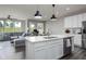 Modern white kitchen with stainless steel appliances and an open layout flowing to living space at 14110 Bay Willow Dr, Fishers, IN 46037