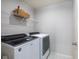 Laundry room with a modern, front-loading washer and dryer and wire shelving at 14110 Bay Willow Dr, Fishers, IN 46037