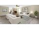 Staged living room featuring a fireplace, neutral decor, and views into the dining room at 14255 Holly Berry Cir, Fishers, IN 46038