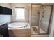 Relaxing bathroom with a soaking tub and a separate shower, tiled with stone at 14982 Dawnhaven Dr, Westfield, IN 46074