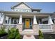 Inviting front porch with stone pillars, white railing, and a vibrant yellow front door at 14982 Dawnhaven Dr, Westfield, IN 46074