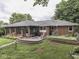 Exterior view of brick home featuring a brick patio with an outdoor seating area and manicured landscaping at 1504 Mcclure Rd, Columbus, IN 47201